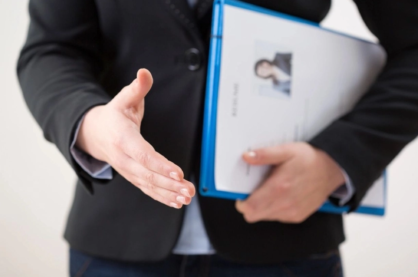 A person holding an open hand and a folder