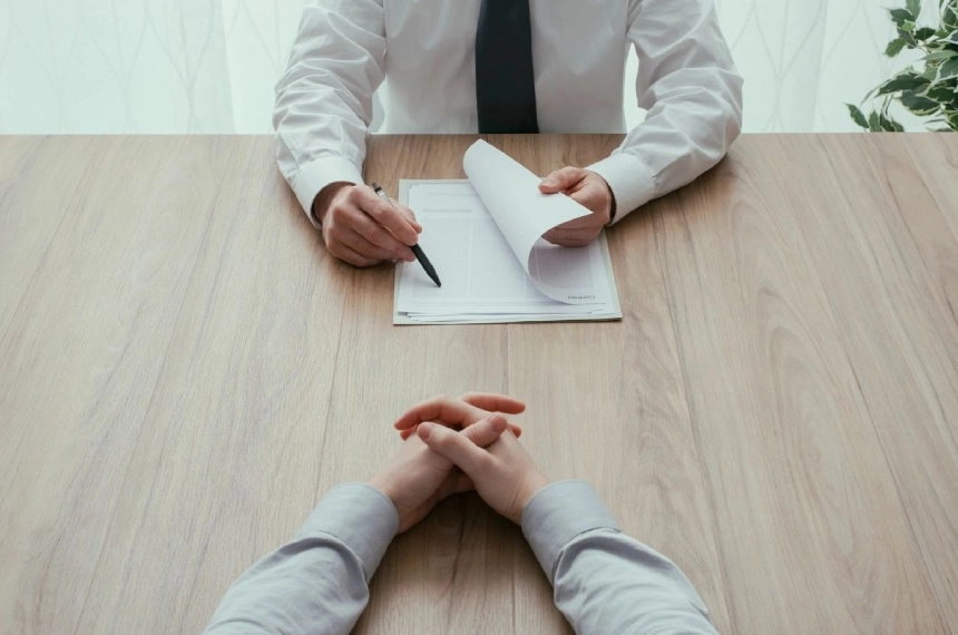 A man is interviewing someone at the table.