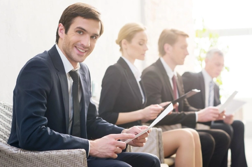 A man sitting in front of other people holding ipads.