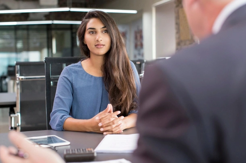 A woman sitting at a table with another man.