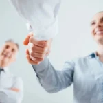 Two people shaking hands in a room.