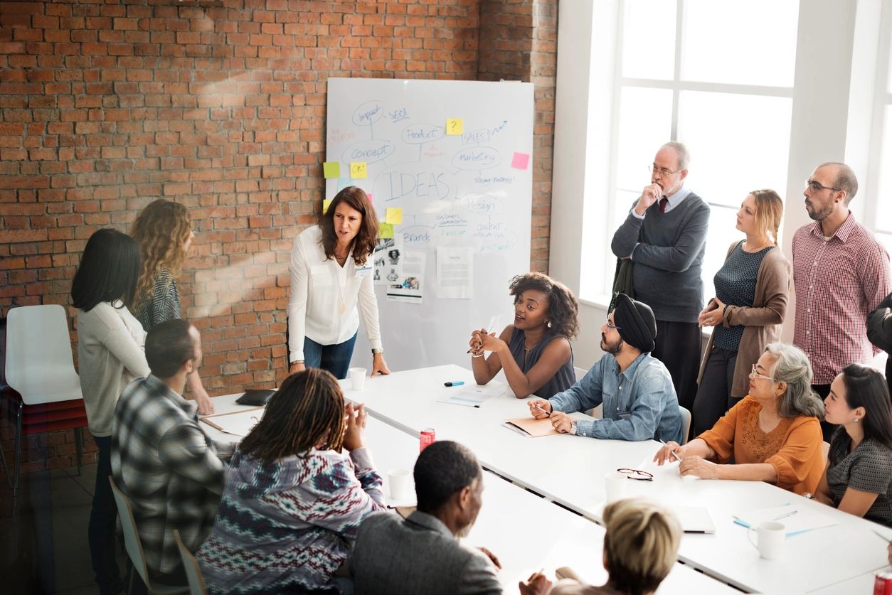 Team meeting with woman presenting at conference table