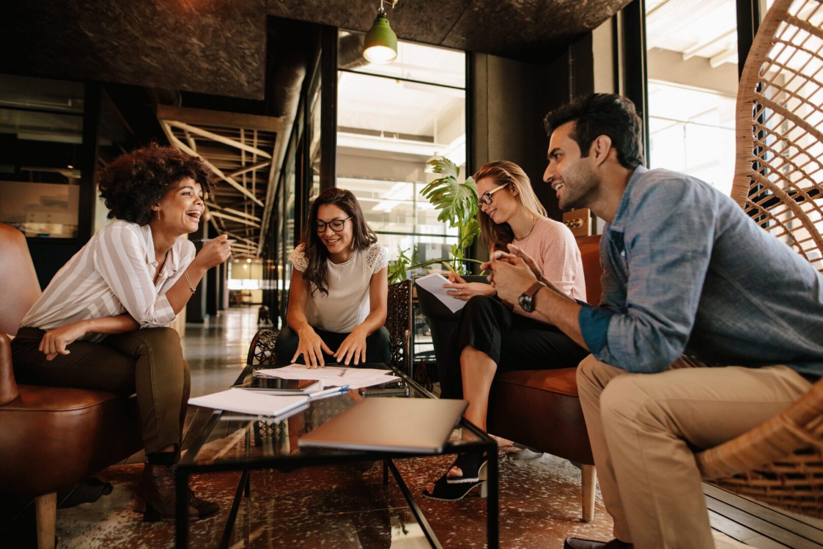 Young colleagues laughing during casual workspace meeting