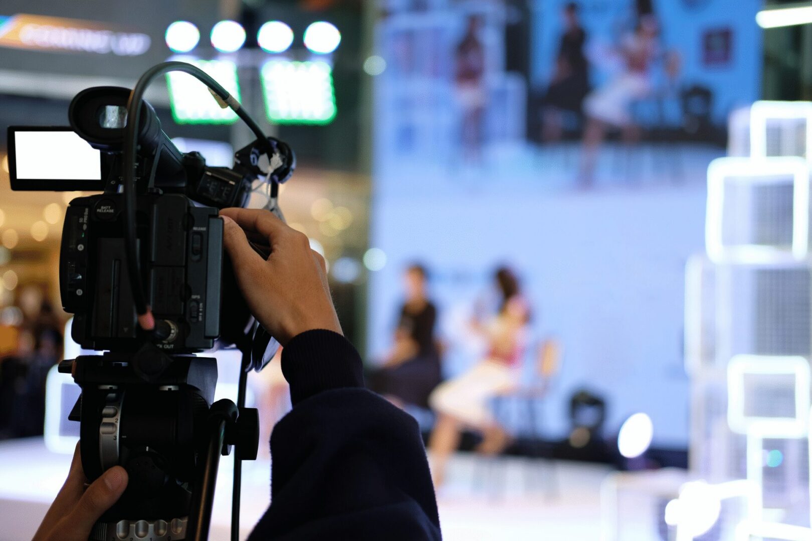 Camera operator filming two people on stage
