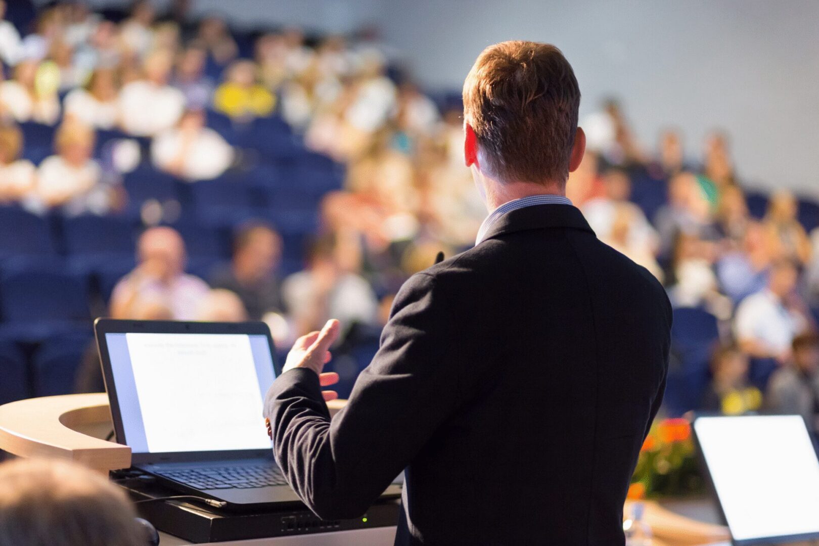 Speaker presenting to audience at conference