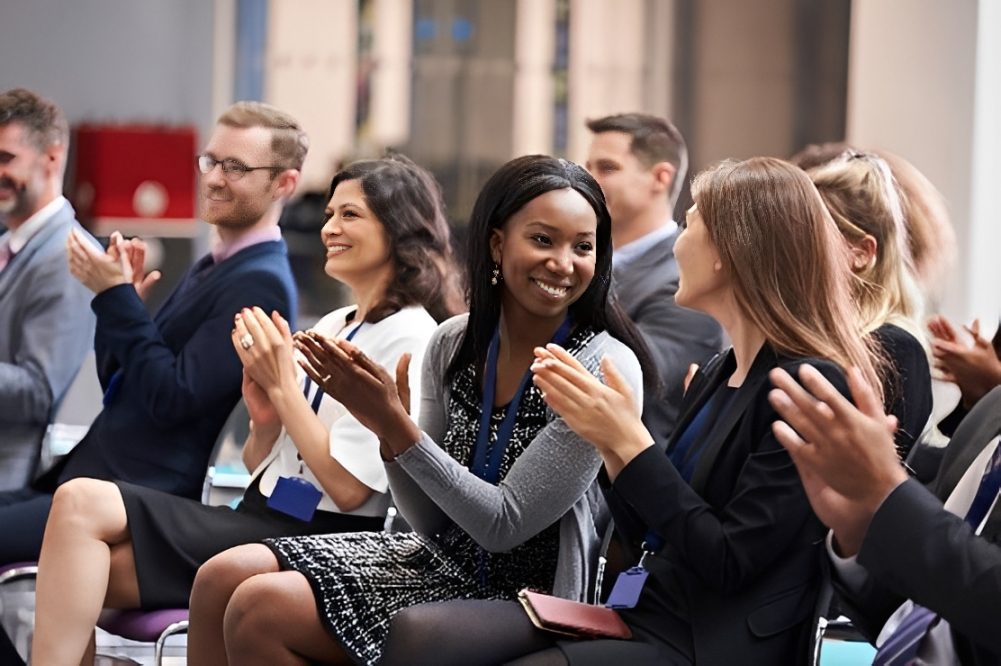 Diverse professionals applauding at conference